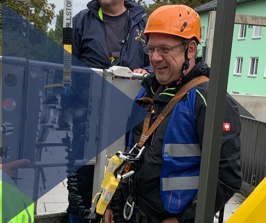 Axel Hahn mit Schutzhelm und persönlicher Schutzausrüstung in einer Arbeitsbühne